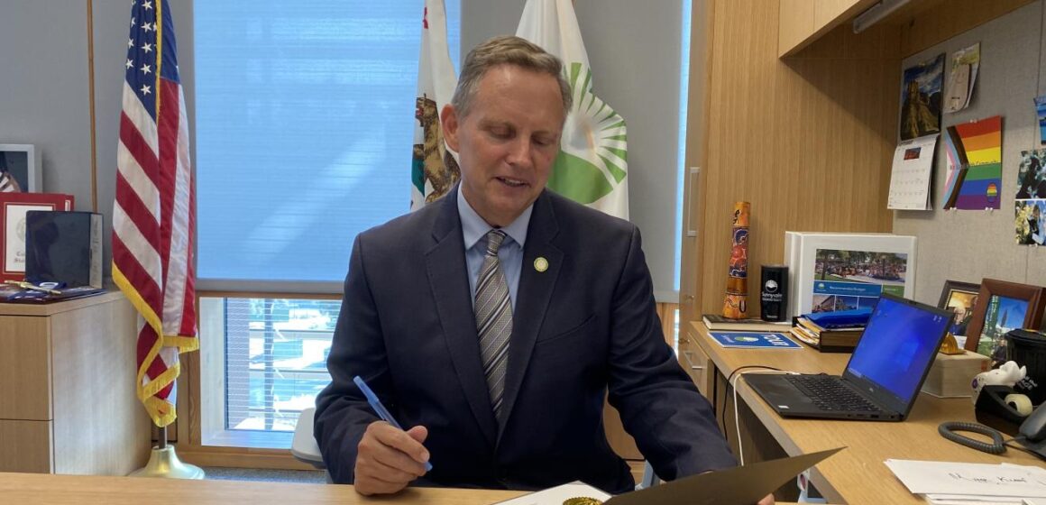 Sunnyvale Mayor Larry Klein signs a certificate in his office.