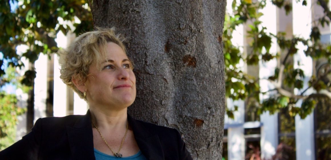 A woman standing in front of a tree