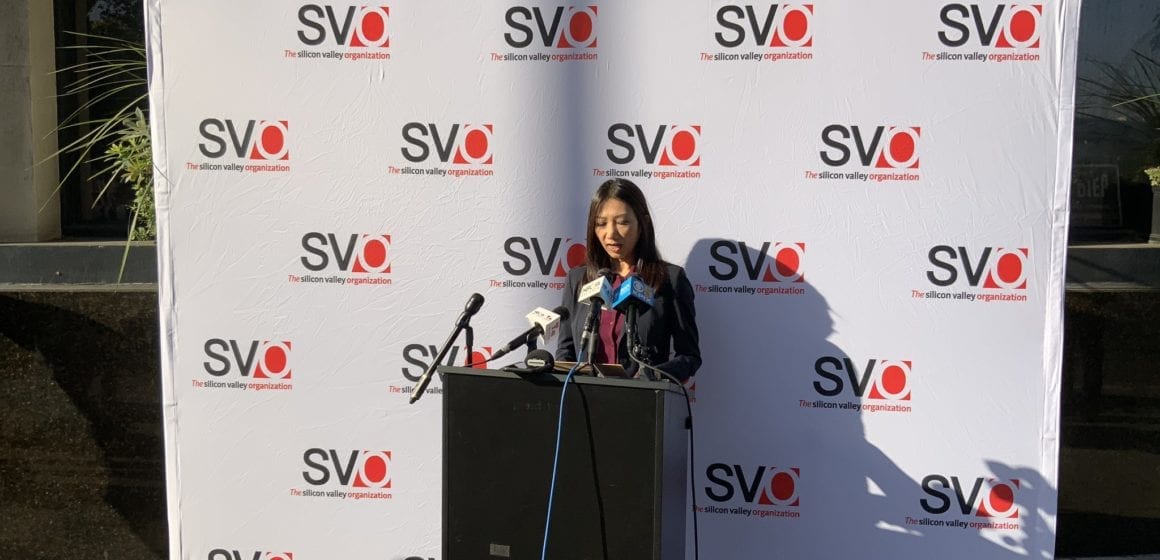 A woman stands at a podium at a news conference in San Jose