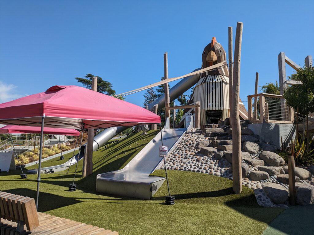 A red pop-up canopy attempting to shade a metal slide at the newly renovated Emma Prusch Farm Park