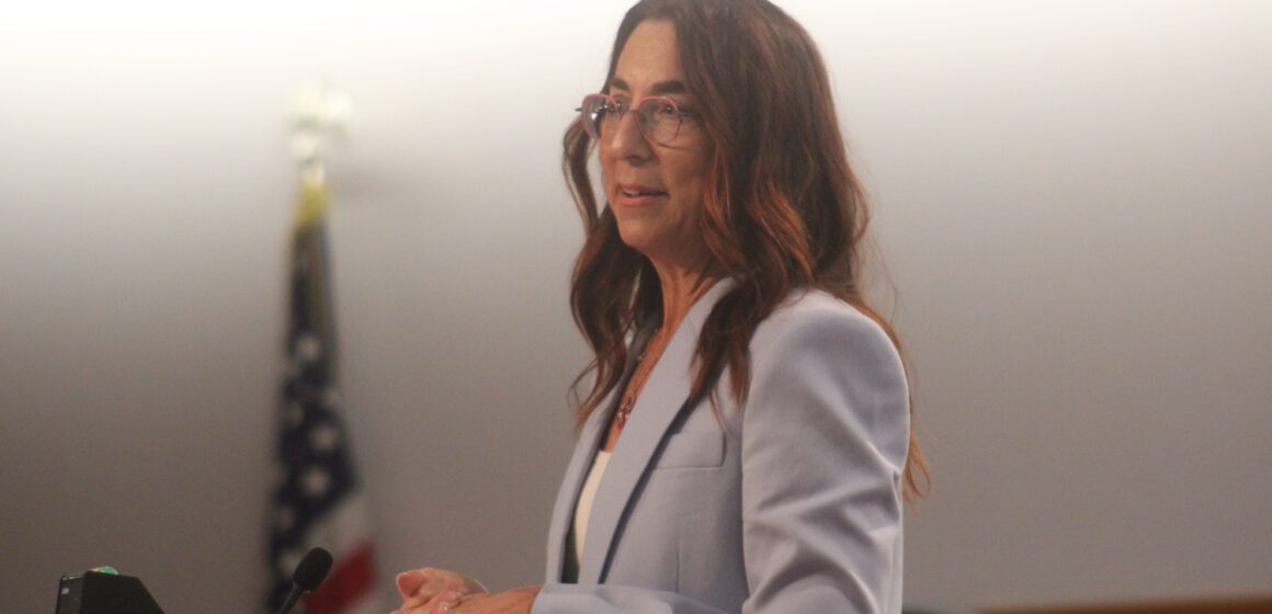 A woman stands at a podium.