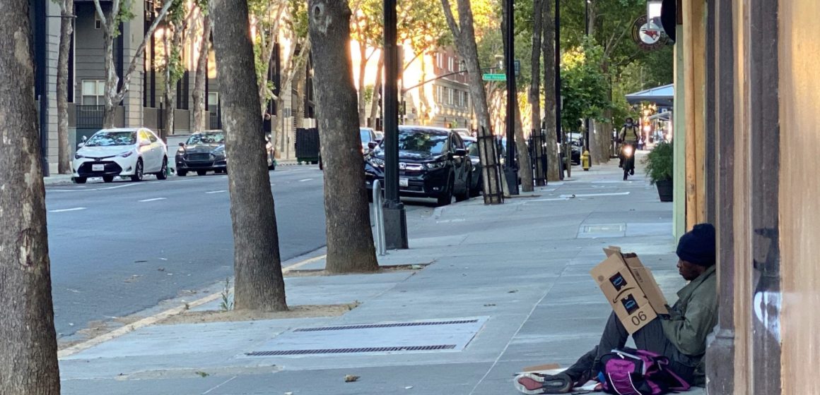 A homeless man sits on the corner of Third and Santa Clara streets in downtown San Jose. Photo by Ramona Giwargis.