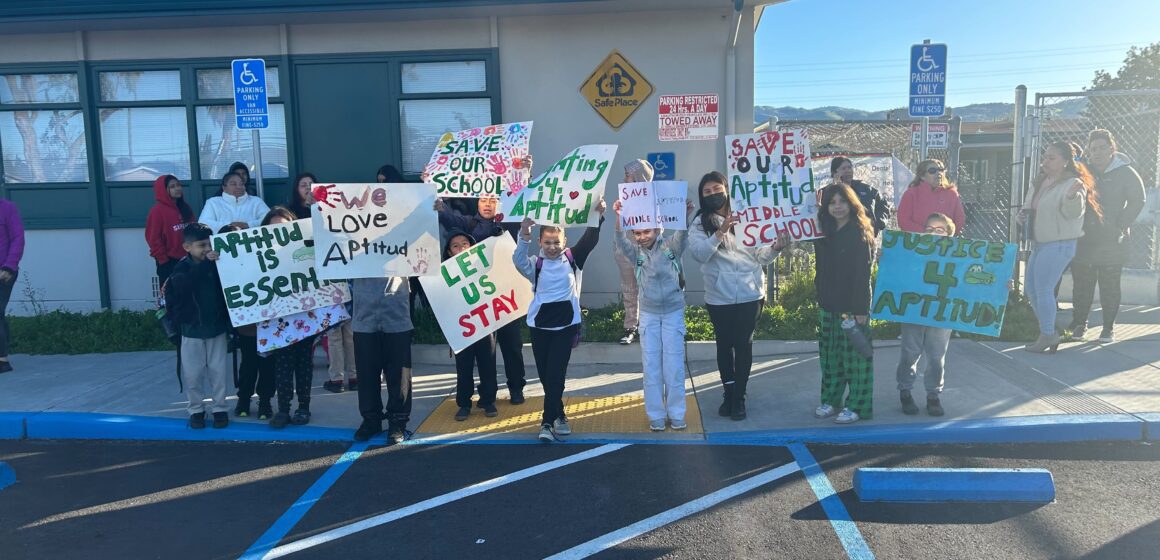 Middle school students hold protest signs outside their campus