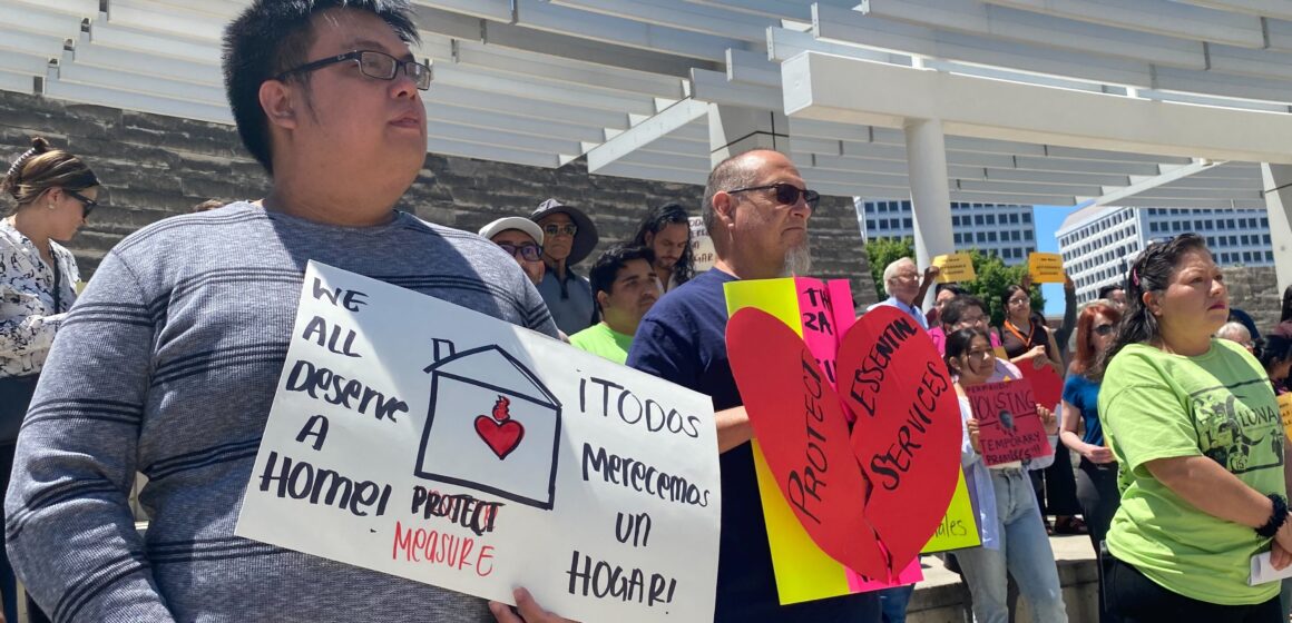 Protesters stand with signs outside San Jose City Hall