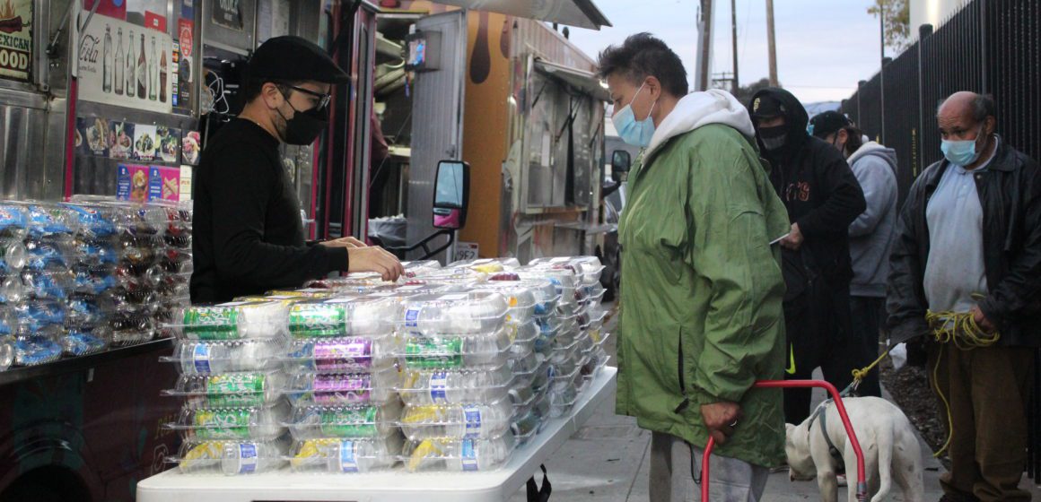 People line up for food and other services on the sidewalk just outside community service nonprofit CityTeam's San Jose center Dec. 25. File photo by Vicente Vera.