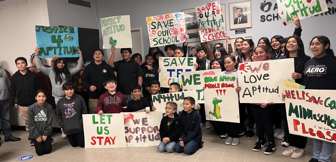 Students stand with protest signs