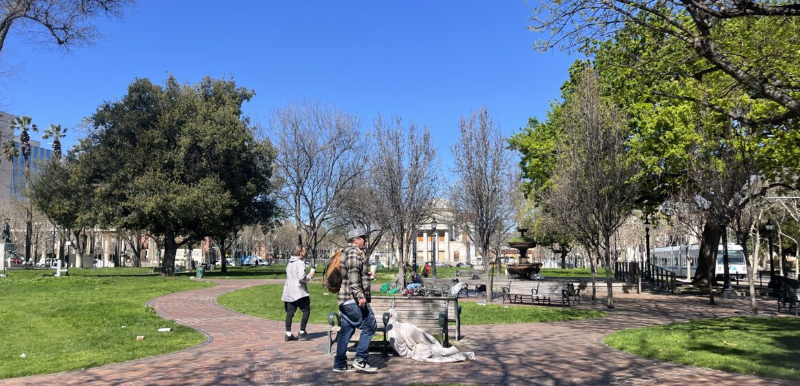 People stand in St. James Park in downtown San Jose