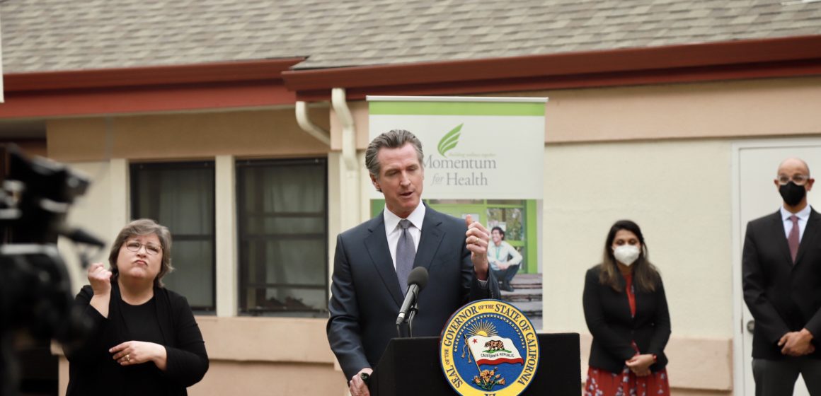 California Governor Gavin Newsom stands at a podium in San Jose