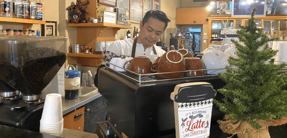 Bean Scene Café owner Kenny Lam pulls espresso shots and steams milk for a customer's latte.