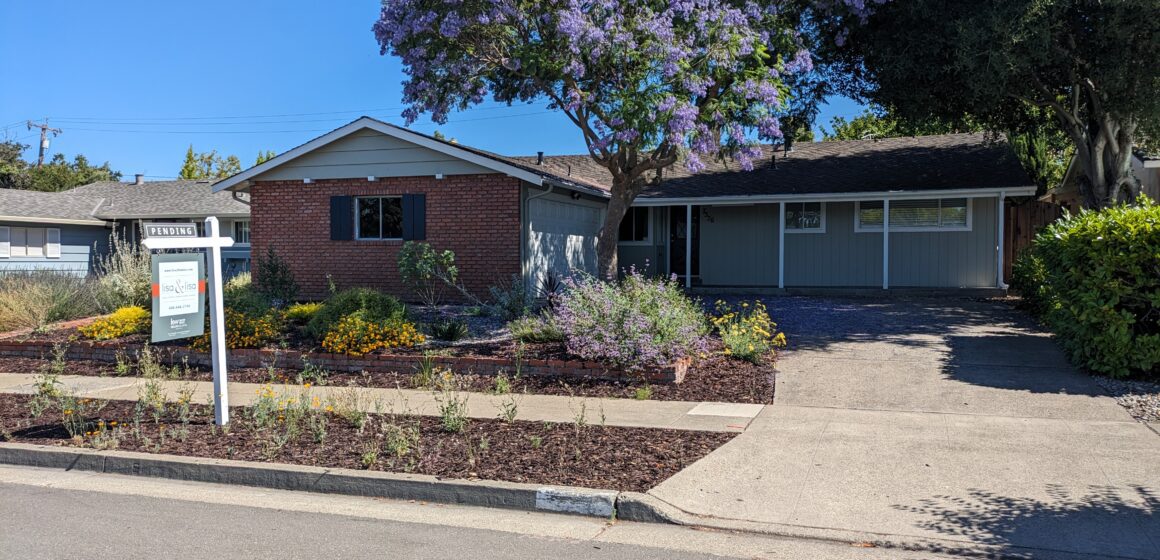 A single-story house on a residential street in Cupertino. A sale pending sign is posted outside