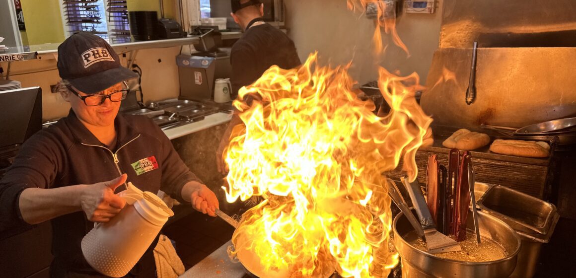 A chef cooks shrimp inside a restaurant kitchen