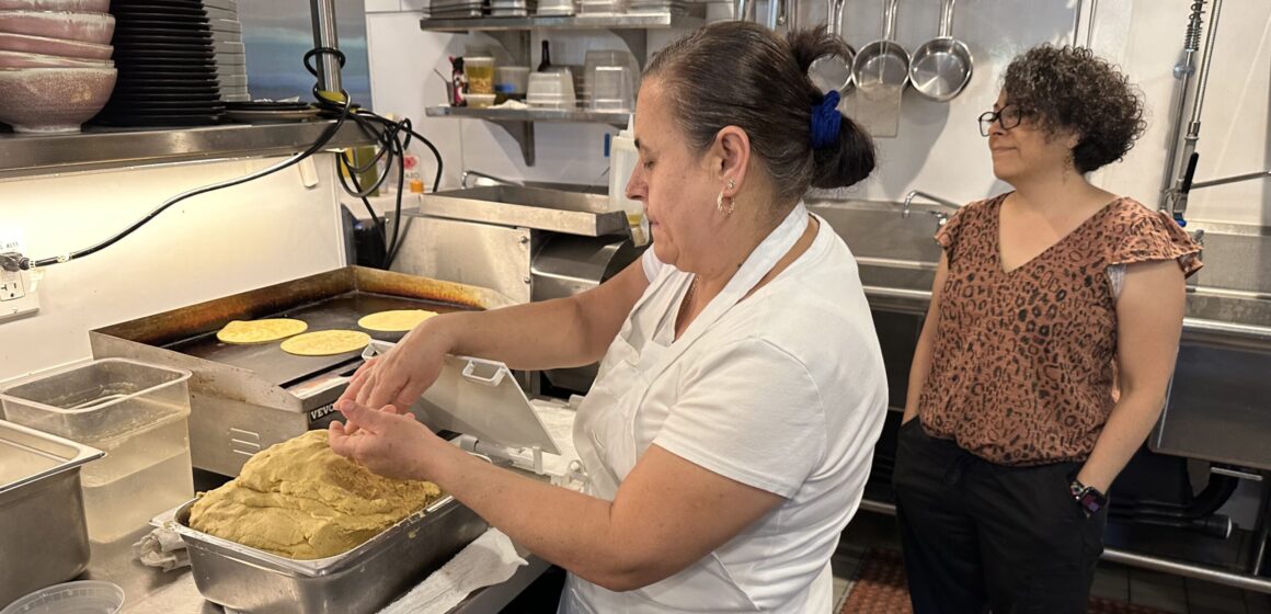 Acopio employee Sara Cardenas making corn tortillas as restaurant owner Lorena Vidrio watches. Photo by Robert Eliason.