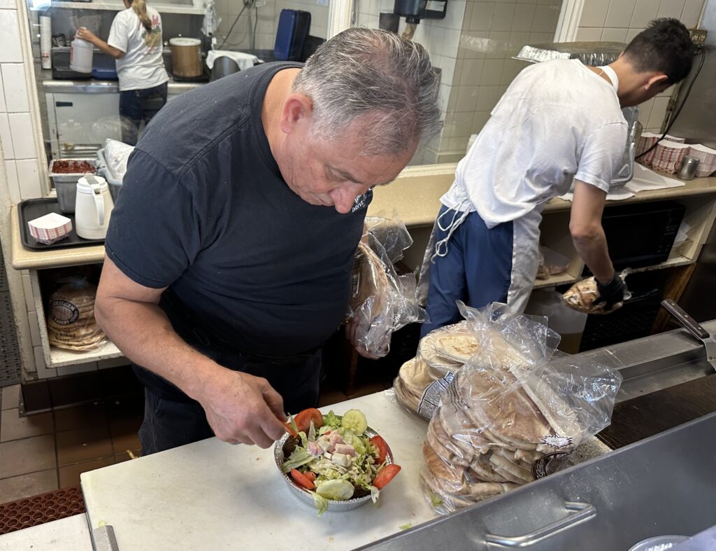 William Nijmeh preparing falafel salad. Photo by Robert Eliason.