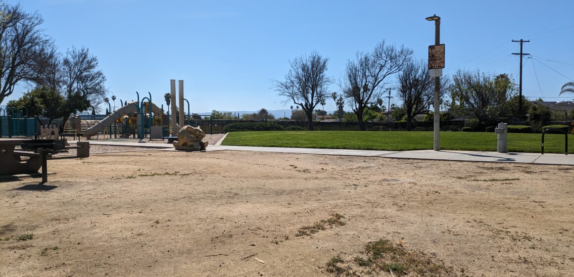 A photo of Sylvia Cassell Park in San Jose, where Councilmember Peter Ortiz said a pirate ship play structure used to be. Visible in photo: A blank gravelly space with a play structure and a slide in the background.