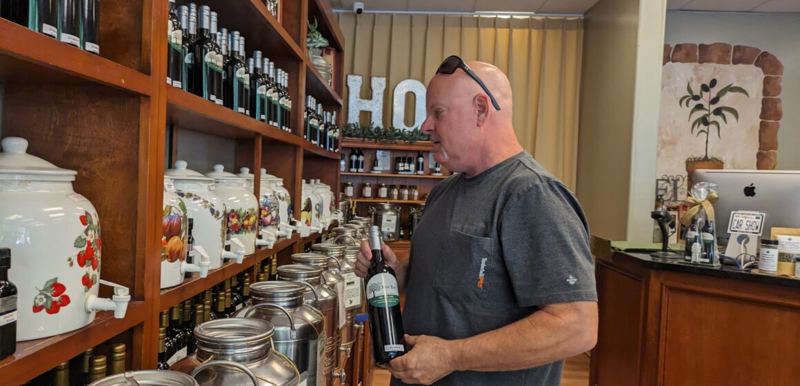 Shop owner looking at a shelf of merchandize.