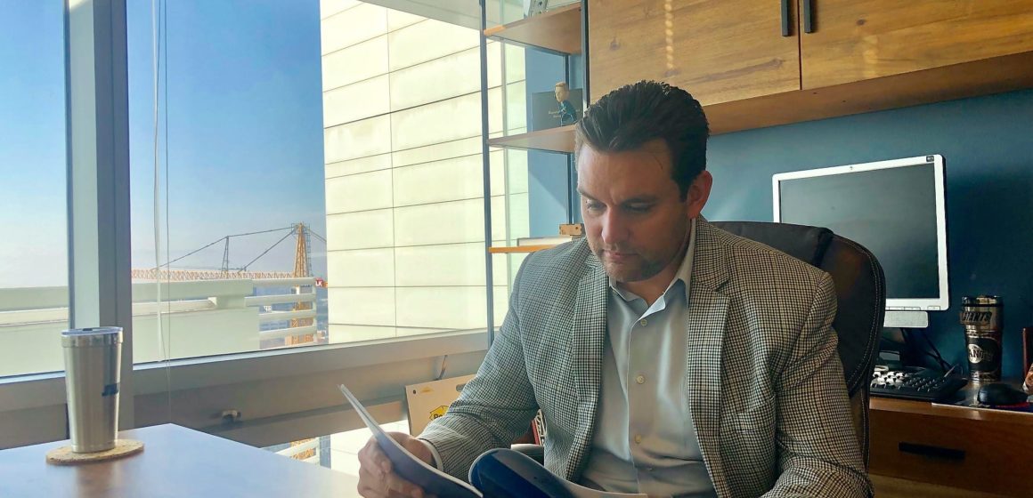 Man sitting at desk reading documents.