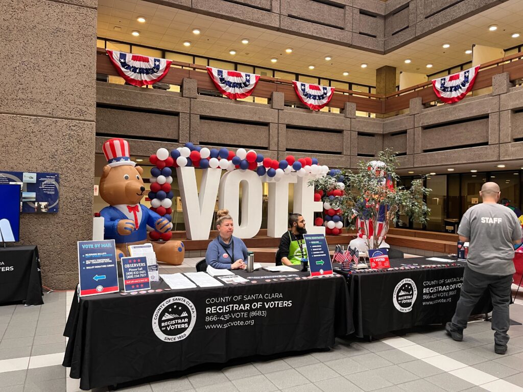 People sitting at a table in the Santa Clara County Registrar of Voters office on Election Day