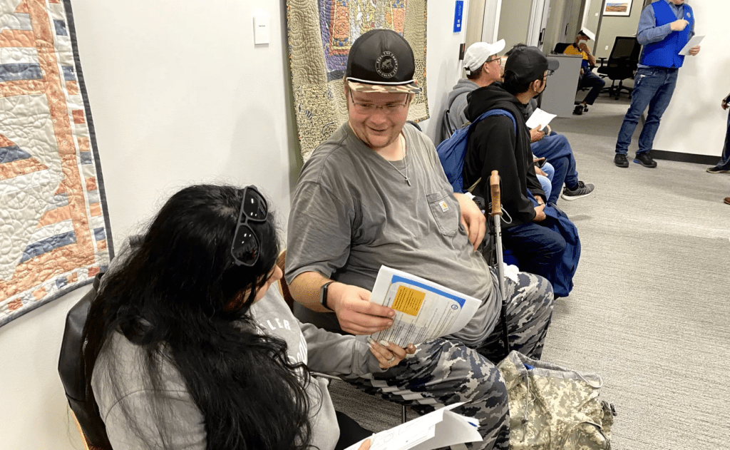 People sitting on chair in hallway waiting in line