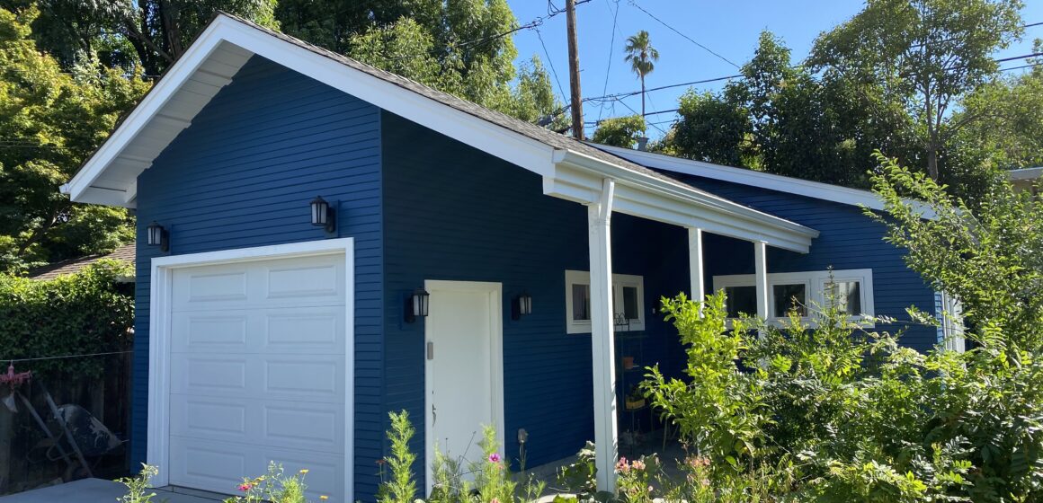 A blue ADU in San Jose surrounded by green bushes. Courtesy of Acton ADU