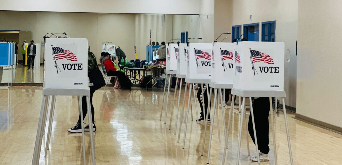 People at voting booths inside an elections office