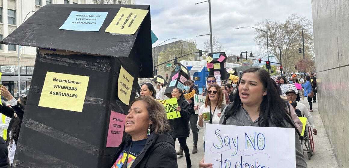 Women holding signs and marching on the sidewalk in support of tenant protections in San Jose.