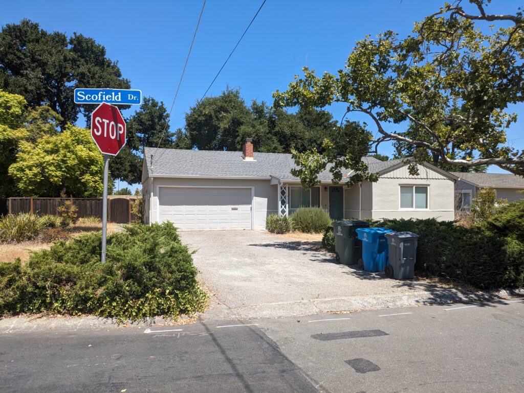 A single-story, gray house in a residential neighborhood in Cupertino on Scofield Drive