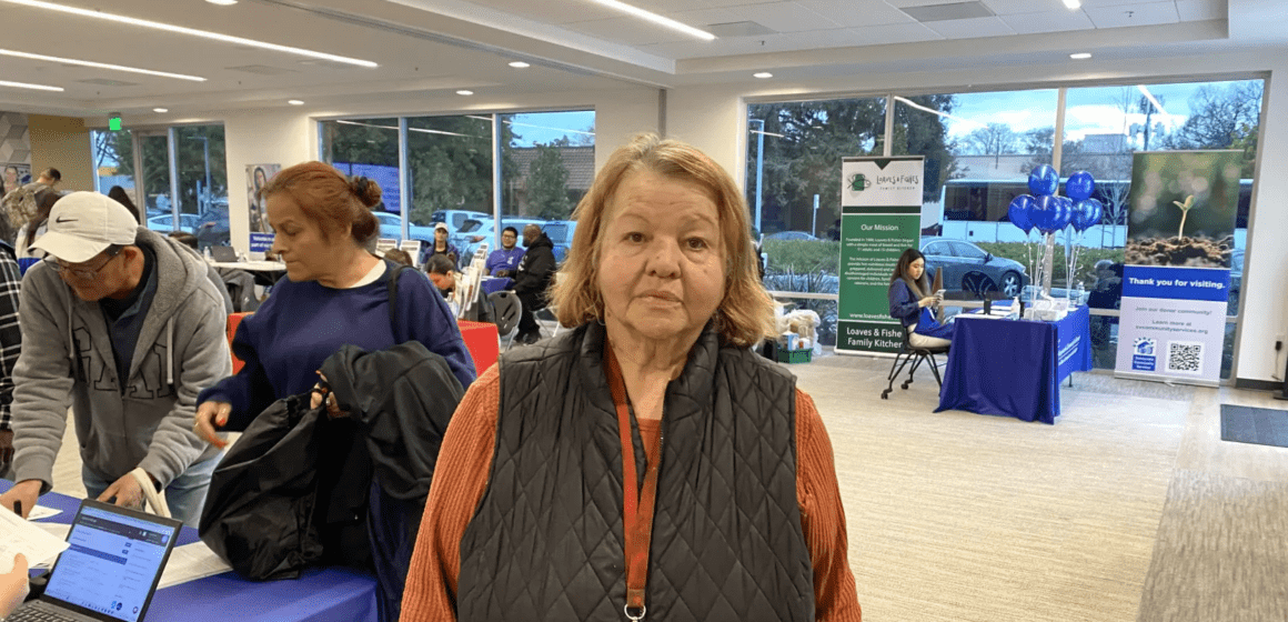 Elderly woman standing in small convention hall