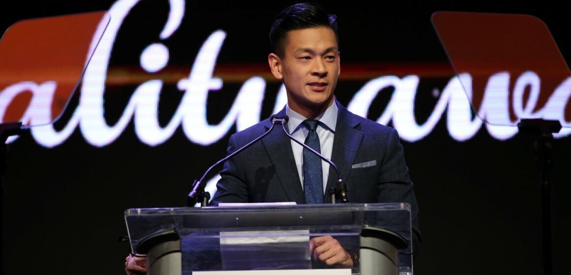 A man in a suit standing at a podium